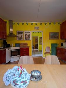 a kitchen with yellow walls and a table with a bowl on it at Ferienwohnung Käthe in Filipstad