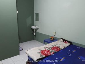 a small room with a bed and a sink at Kelimutu Lodge in Kelimutu