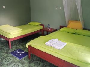 two twin beds in a room with two tables at Kelimutu Lodge in Kelimutu