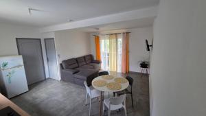 a living room with a table and a couch at le Chant des vagues 1 in Saint-Philippe +2 photos