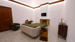 a living room with a bed and a couch and a television at The Suite - Trani centro in Trani +33 photos