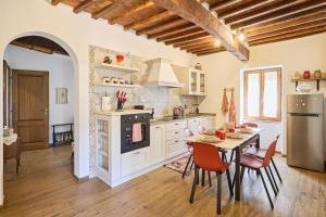 a kitchen with a table and chairs and a refrigerator at CasaBianchini Charming Home Val d'Orcia in Monticchiello