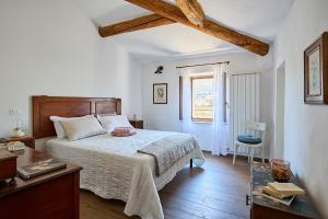 a bedroom with a bed and a table and a window at CasaBianchini Charming Home Val d'Orcia in Monticchiello