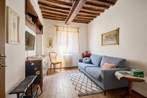 a living room with a blue couch and a window at CasaBianchini Charming Home Val d'Orcia in Monticchiello