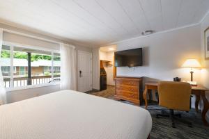 a hotel room with a bed and a desk with a computer at Scotty's Lakeside Resort in Lake George +75 photos