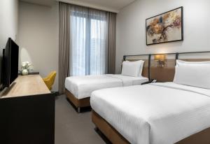 a hotel room with two beds and a television at Bomonti Suites Istanbul in Istanbul