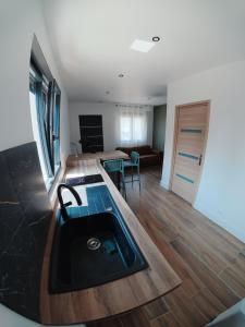 a kitchen with a sink and a living room at Cosy et Calme in Cholet