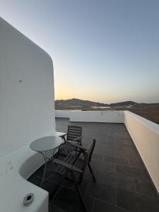 a patio with two chairs and a table on a roof at Klouvas apartment in Klouvas