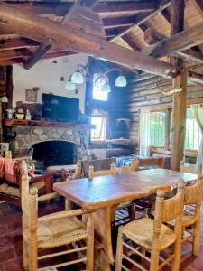 a dining room with a wooden table and a fireplace at El Rancho in Villa Giardino