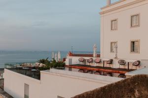 a building with a balcony with a view of the ocean at Memmo Alfama - Design Hotels in Lisbon