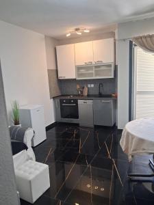 a kitchen with white cabinets and a black floor at La Diva Adriatica in Podstrana