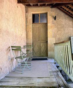 a pair of chairs sitting in front of a door at Maison Constant - Le Camélia in Autun