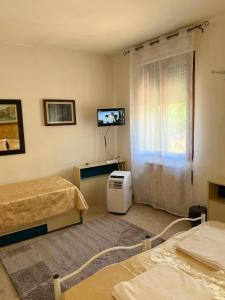 a room with two beds and a tv and a window at Lovenice Center Royalclass in Venice