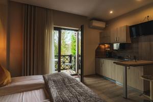 a bedroom with a bed and a kitchen with a balcony at Amethyst in Sovata