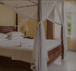 a bedroom with a canopy bed and a window at Mama Maendeleo Resort in Hindi +7 photos
