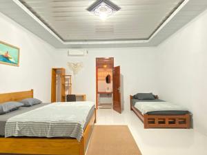 a bedroom with two beds and a ceiling at Surak Villa Mentawai in Katiet