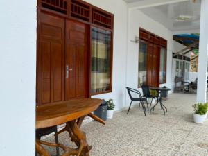 a porch with a wooden cabinet and chairs at Surak Villa Mentawai in Katiet +15 photos