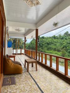 a room with a balcony with a bench and a table at Surak Villa Mentawai in Katiet