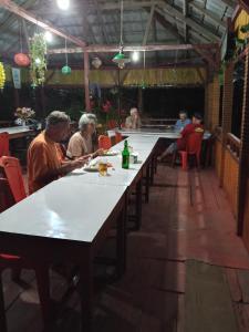 a group of people sitting at tables in a restaurant at Kelimutu Lodge in Kelimutu