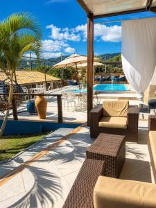a patio with a table and chairs and a pool at Vilarejo Cipó in Serra do Cipo