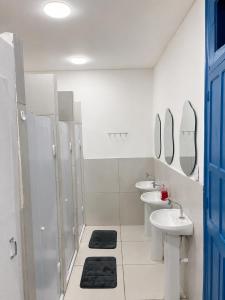 a bathroom with two sinks and two mirrors at Casa Mykonos Rio in Rio de Janeiro
