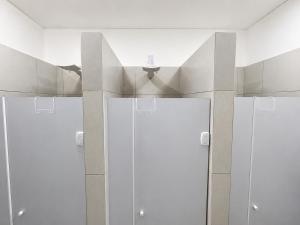a bathroom with four white doors in a room at Casa Mykonos Rio in Rio de Janeiro