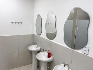 a bathroom with two sinks and mirrors on the wall at Casa Mykonos Rio in Rio de Janeiro