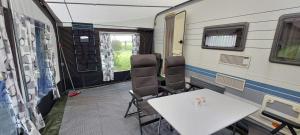 a room with a table and chairs in a trailer at Koolmees in Erica