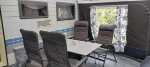 a dining room with chairs and a table in an rv at Koolmees in Erica