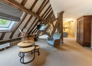 a attic room with a bed and a table and a chair at Hotel Winselerhof by Flow in Landgraaf