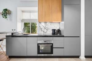 a kitchen with white cabinets and an oven at Homly S22 in Riga