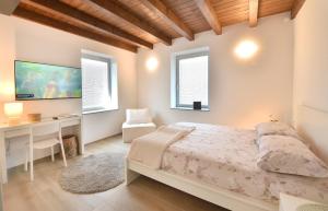 a bedroom with a bed and a desk and windows at Alla Corte del Gallo in Tricesimo