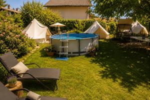 a backyard with a hot tub and some tents at RoseArt Nest Studio in Ljubljana