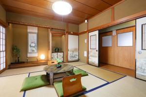a living room with a table and green chairs at 民泊 Vacation rental "Tajimi-jyuku Kitaya" Base for trips to Ghibli Park,Tsumago-juku,Magome-juku in Tajimi