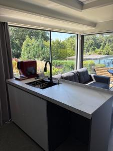 a kitchen with a counter with a sink and a couch at Capsule house for rent at Gut Holtmann in Billerbeck +4 photos