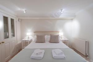 a white bedroom with a large bed with two pillows at Apartment Jamaica Street 7 in Edinburgh