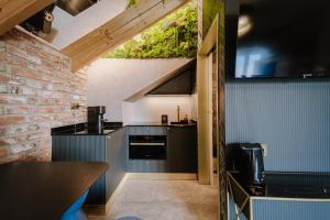 a kitchen with black appliances and a brick wall at Apartamenty Wieliczka in Wieliczka