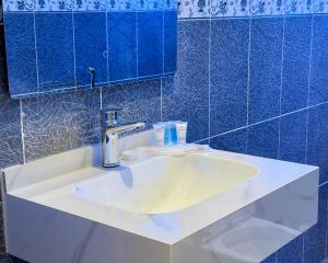 a bathroom with a sink and a blue tiled wall at أجنحة كتارا صلالة Katara Suites Salalah in Salalah +25 photos