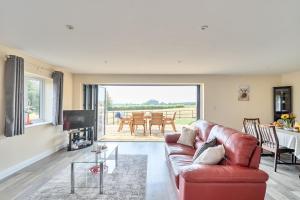 a living room with a red couch and a television at The Donkey Shed in Sherborne