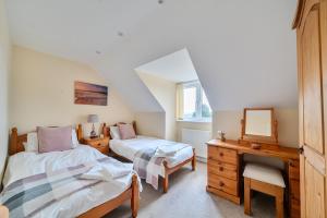a bedroom with two beds and a desk and a mirror at The Donkey Shed in Sherborne