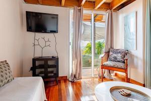 a living room with a couch and a tv at KAZUBUNTU in Saint-Leu