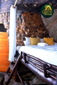 a bed in a room with a stone wall at Giripura Resort - Kandy in Kandy