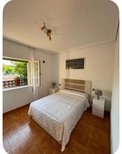 a bedroom with a bed and a large window at El Rincón de pedreña in Pedreña