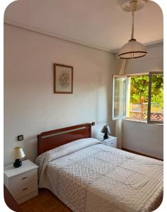 a bedroom with a bed and two night stands and a window at El Rincón de pedreña in Pedreña
