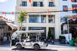 a golf cart parked in front of a building at Horizon Minh Chau Hotel in Quang Ninh