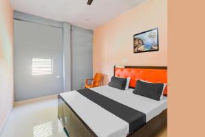 a bedroom with a large bed with an orange headboard at Hotel O Luxury Palace in Malīhābād