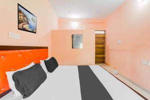 a small room with a bed with an orange headboard at Hotel O Luxury Palace in Malīhābād