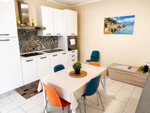 Grab a Flat in Coroneo في ترييستي: مطبخ وغرفة طعام مع طاولة وكراسي