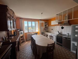 a kitchen with a table and a kitchen with a tableablish at Maison familiale 10 pers à St Setiers in Saint-Setiers