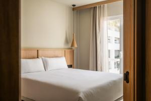 a bedroom with a white bed and a window at Apartamentos Estival Park in La Pineda
